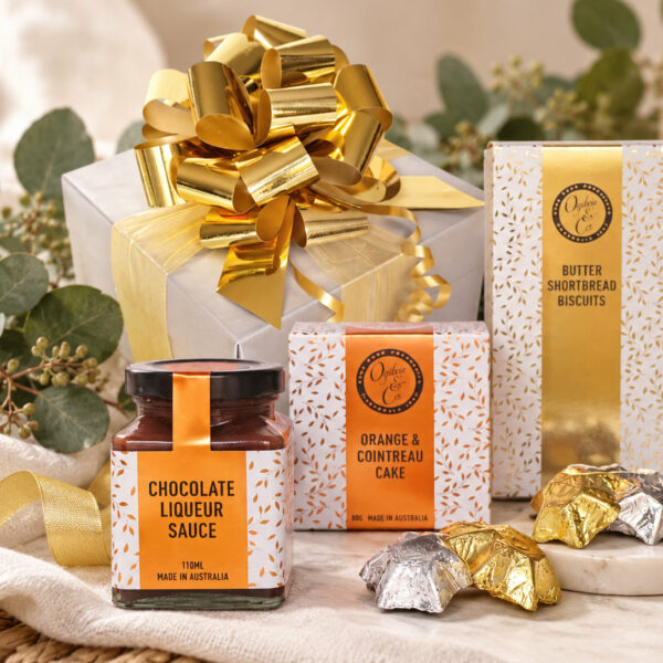 Little Merry Christmas gift hamper with Ogilvie & Co treats, silver gift box, gold bow and festive eucalyptus styling.